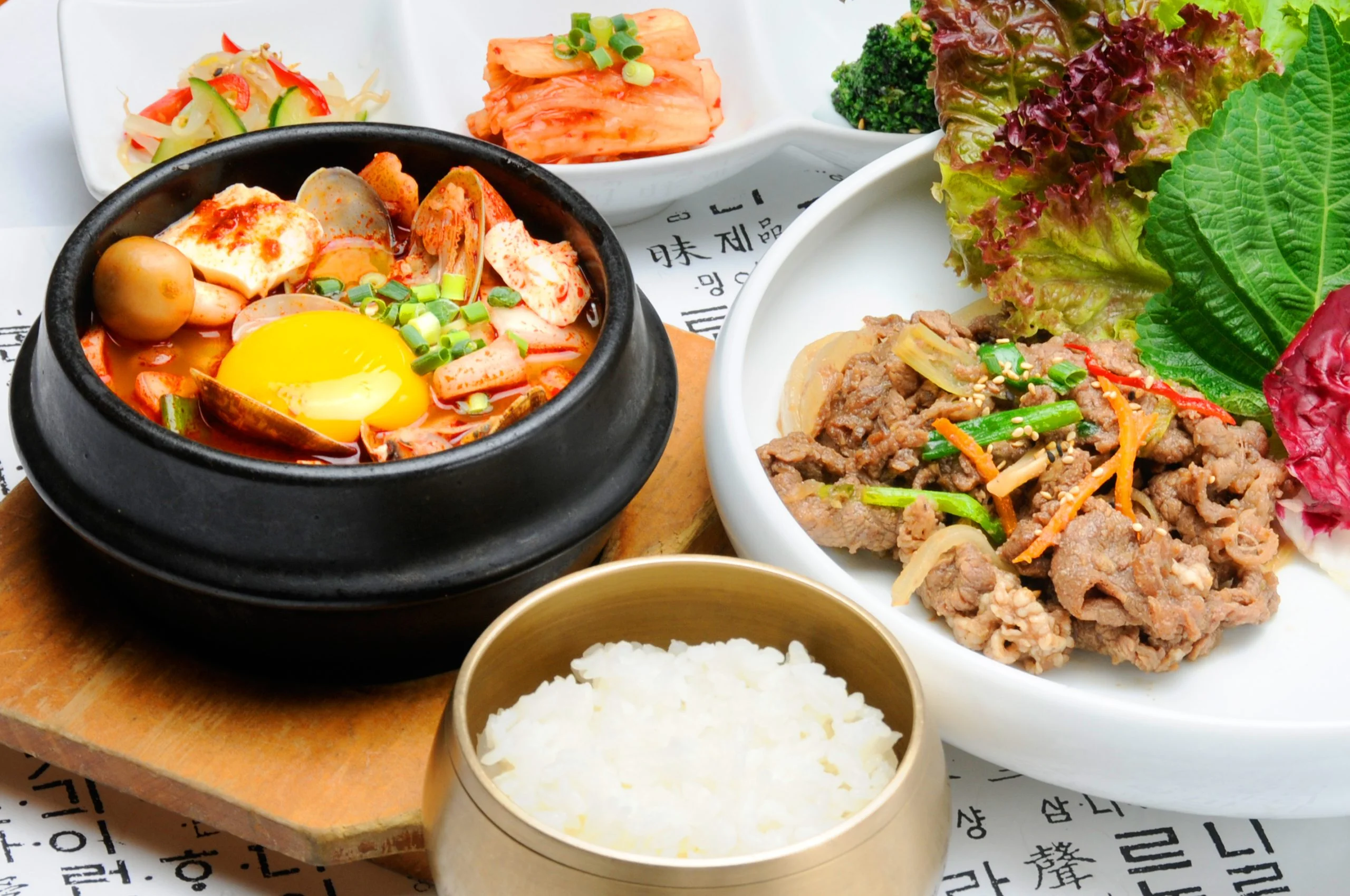 湯気が立つスンドゥブチゲと韓国料理の定食